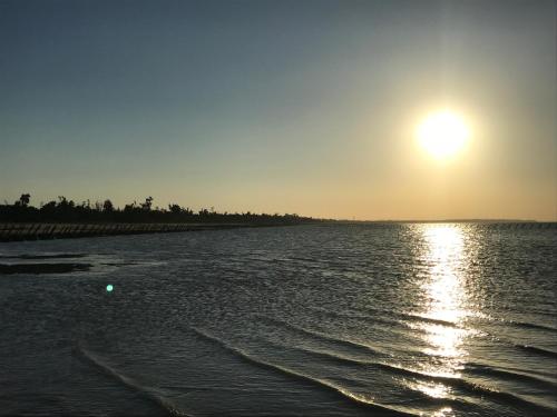 a sunset over a body of water with the sun in the sky at Kinmen Laoye B&B in Jinhu