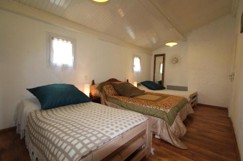 une chambre avec deux lits dans une pièce dans l'établissement Montloubier, à Villeuneuve-de-Berg