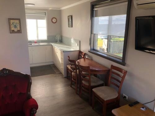 a kitchen and dining room with a table and chairs at Waratah Falls Holiday Unit in Waratah