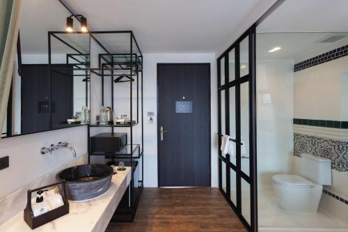 a bathroom with a sink and a toilet at Oriental Heritage Residence in Bangkok