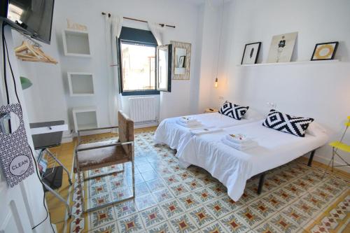 a bedroom with a white bed and a chair at Pension Casa Pinilla in Cascante