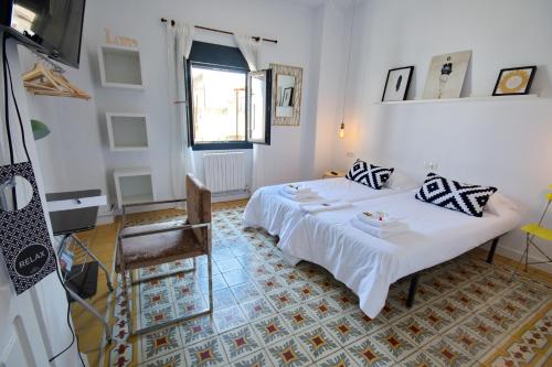 a bedroom with a white bed and a chair at Pension Casa Pinilla in Cascante