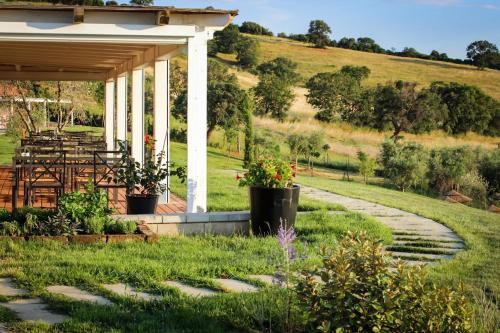 a garden with a gazebo and a path at Podere n°8 Agriturismo in Maremma in Alberese