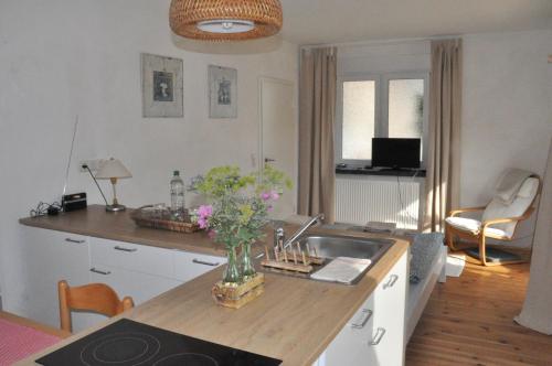 a kitchen with a sink and a vase of flowers on a counter at Pension (FW) "Seeblick" am Stelzenhaus in Dornburg