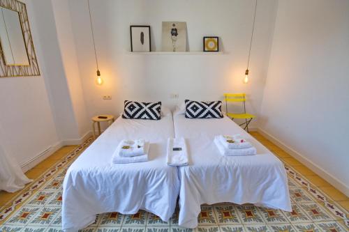 a bedroom with a white bed with towels on it at Pension Casa Pinilla in Cascante