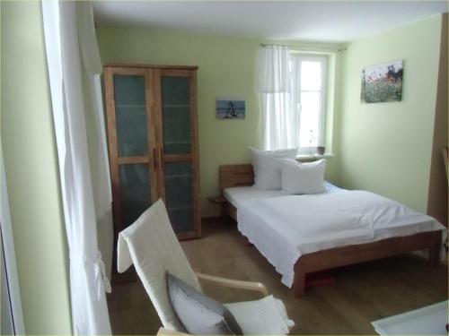 - une chambre avec deux lits, une chaise et une fenêtre dans l'établissement Fewo 1 Waren Müritz - Haus Buchen am Tiefwarensee - 1 Zi, à Waren