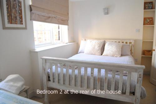 a bedroom with a crib in a room with a window at High Street Apartment in Uppingham