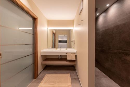 a bathroom with a sink and a shower at Hotel Winzerhof in Termeno