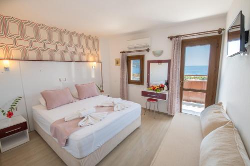 a bedroom with a large bed with a view of the ocean at Hotel Pirat in Kalkan