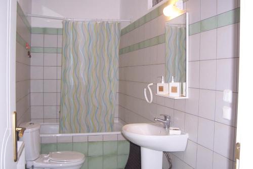 a bathroom with a sink and a toilet and a tub at Christina's House in Iraklitsa