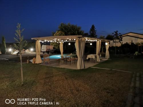 einen Pavillon mit einem Tisch und Stühlen darunter in der Unterkunft Cà Thomas in Castelnuovo Magra