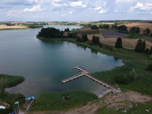an aerial view of a lake with a cross in the water at Jaskółka - pokoje i apartament przy plaży in Olsztyn