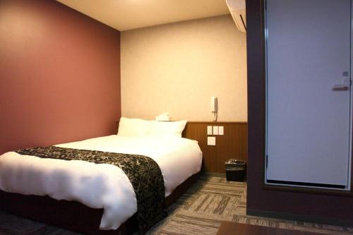 a hotel room with a bed and a large window at Hotel Neo World in Osaka