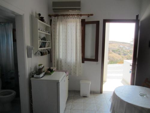 een keuken met een deur naar een kamer met een raam bij Katerina Apartments in Triovasálos