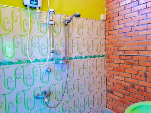 um chuveiro com uma mangueira ligada a uma parede de tijolos em Leisure Villa em Colombo