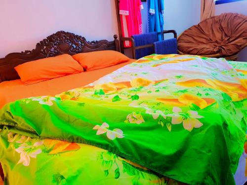 a green and orange bed with flowers on it at Leisure Villa in Colombo