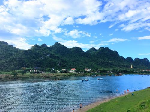 a body of water with mountains in the background at Son River House in Phong Nha