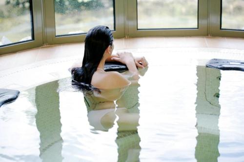 a woman is sitting in a bath tub at Rothay Garden Hotel & Riverside Spa in Grasmere