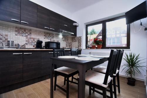 a kitchen with a table and chairs in a kitchen at Residence SINAIA Apartments in Sinaia