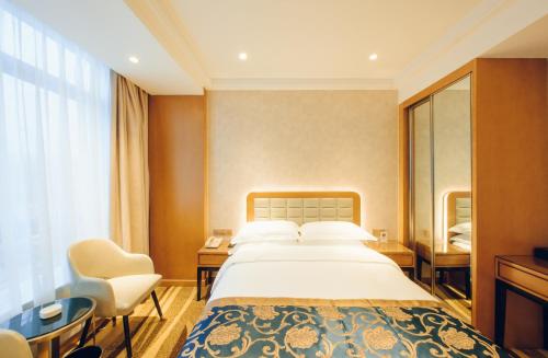 a hotel room with a large bed and a window at Wenzhou Hangbin International Hotel in Wenzhou