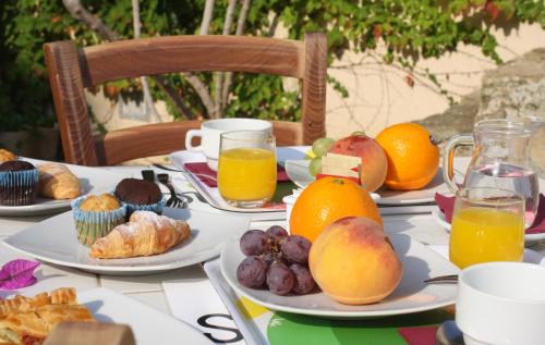 a table with plates of food and fruit on it at Baglio Siciliamo Country House in Noto Marina