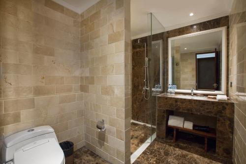 a bathroom with a shower and a toilet and a sink at Grand Palace Hotel Sanur - Bali in Sanur
