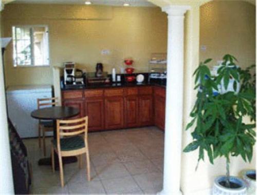 a kitchen with a table and a potted plant at Days Inn by Wyndham Turlock in Turlock