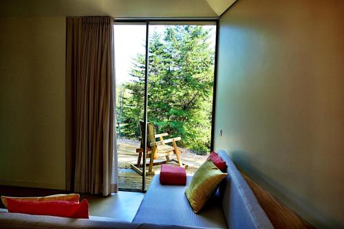uma sala de estar com uma grande janela e um sofá em Herdade Clube Tiro Monfortinho em Monfortinho