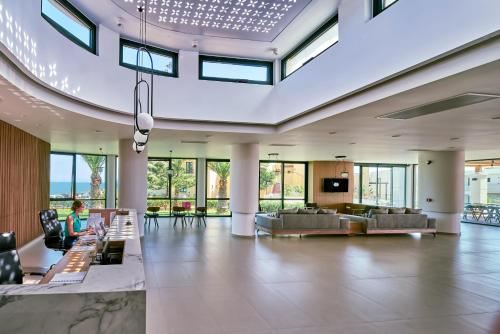 a large lobby with a person sitting in a chair at Silver Beach Hotel & Apartments in Gerani Chanion