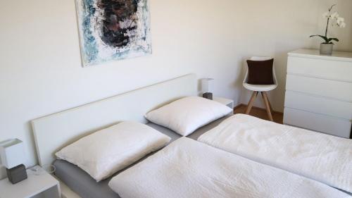 1 dormitorio con 1 cama blanca y 2 almohadas en Appartement Belvedere, en Keutschach am See