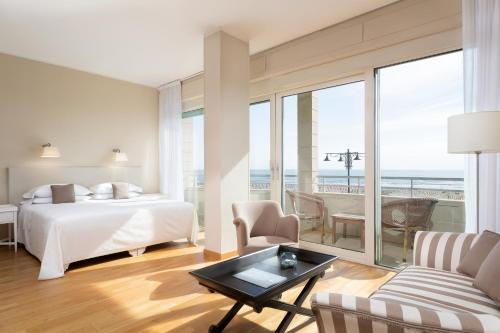 a hotel room with a bed and a view of the ocean at Hotel Sina Astor in Viareggio