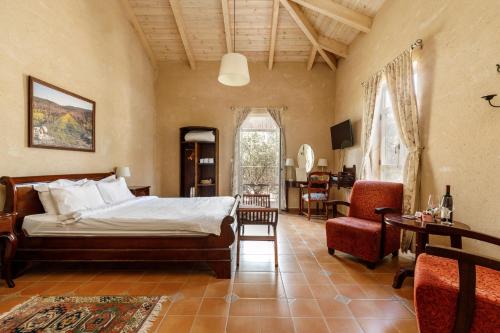 a bedroom with a bed and a table and chairs at Smadar-Inn in Zikhron Ya'akov