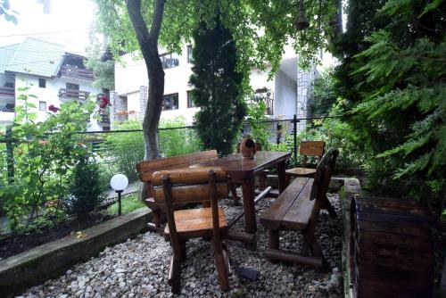 a wooden table and chairs in a garden at Residence SINAIA Apartments in Sinaia