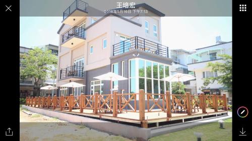 un edificio con una terraza con sombrillas. en 金門樂客民宿, en Jinning