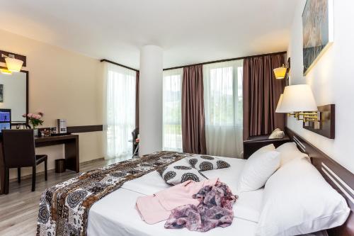 a hotel room with a bed and a desk at Grami Hotel Sofia in Sofia