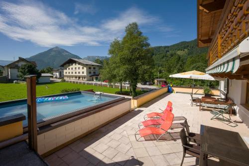 a swimming pool with chairs and a table and a table at Village Apartments in Achenkirch