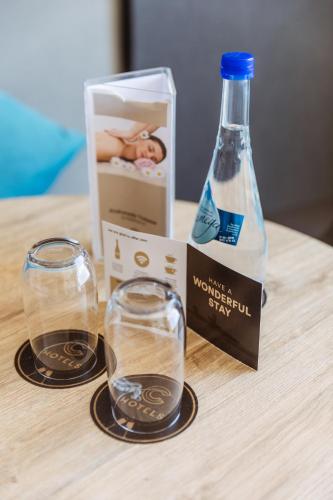 two glasses and a bottle on a wooden table at C-Hotels Andromeda in Ostend