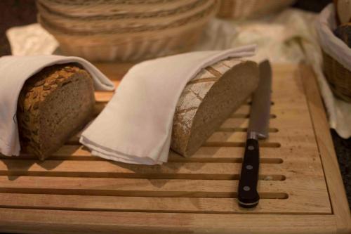 a loaf of bread on a cutting board with a knife at Adventure Camp in Oetz