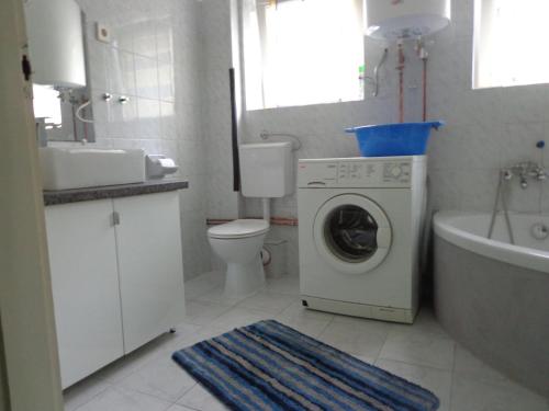 a bathroom with a washer and a sink and a washing machine at Luca-lak in Fonyód