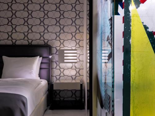 a bedroom with a bed and a wall at H10 Berlin Ku'Damm in Berlin