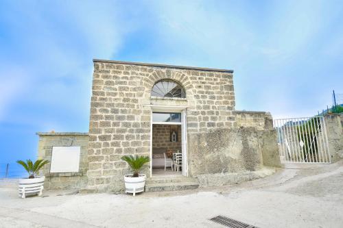 a brick building with two potted plants in front of it at Tenuta C'est la Vie in Ischia