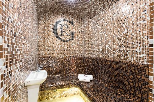 a tiled bathroom with a toilet and a sink at Grami Hotel Sofia in Sofia