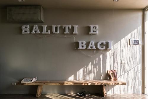 a bench against a wall with a sign for a saluth back at Residenza Rosso Di Sera in Capoliveri