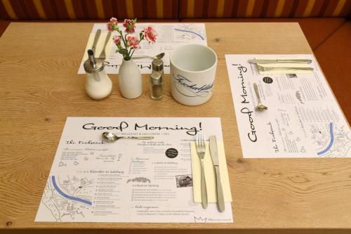 a table with a menu and flowers and utensils at Hotel Krone 1512 in Salzburg