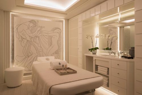 Baño blanco con cama y lavabo en Four Seasons Hotel Megeve, en Megève