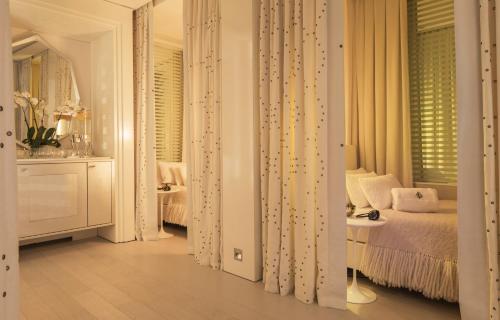 a white bedroom with a bed and a window at Four Seasons Hotel Megeve in Megève