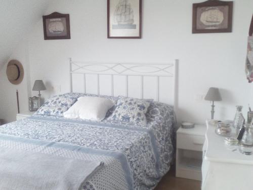 1 dormitorio con 1 cama con colcha azul y blanca en Apartamento de playa, en Boiro