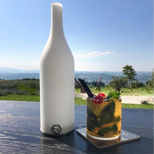 a white bottle and a cup on a table at Idea 18 Boutique Hotel in Controguerra