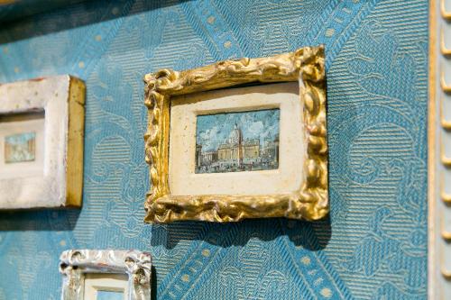 a gold picture frame hanging on a blue wall at Hotel Celio in Rome