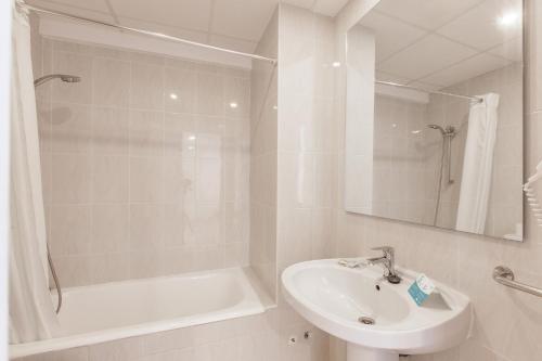 a white bathroom with a sink and a bath tub at BLUESEA Don Jaime in Cala Millor